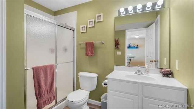 bathroom featuring toilet, a shower stall, and vanity