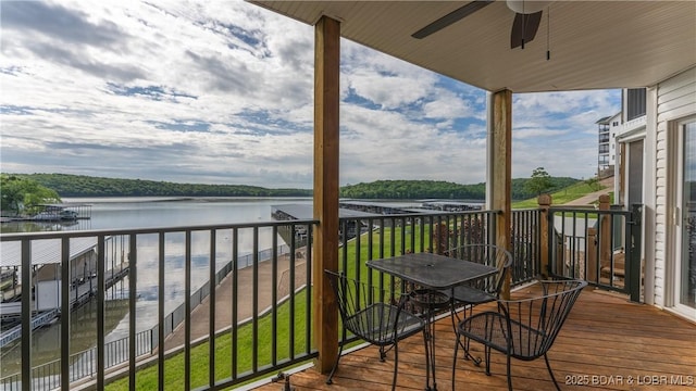 balcony featuring a water view and ceiling fan