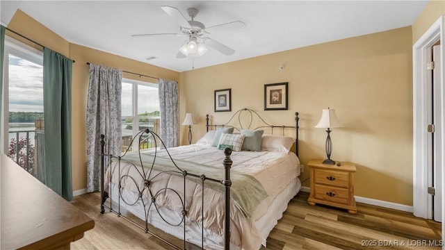 bedroom with baseboards, wood finished floors, and a ceiling fan