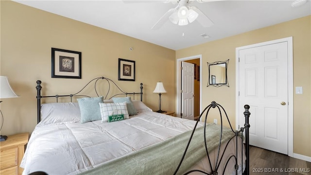 bedroom featuring dark wood finished floors, ceiling fan, and baseboards