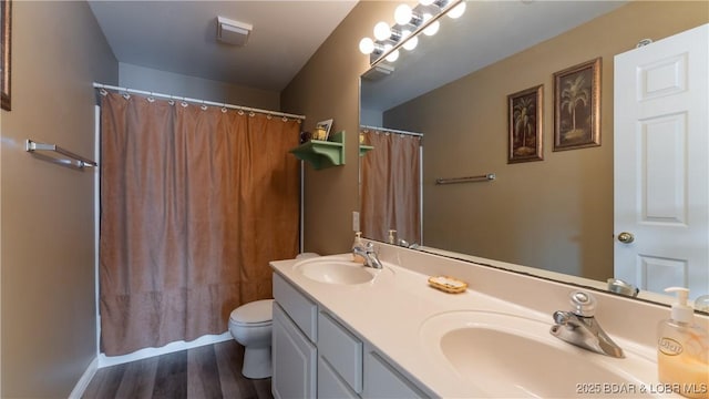 full bathroom featuring toilet, wood finished floors, double vanity, and a shower with curtain