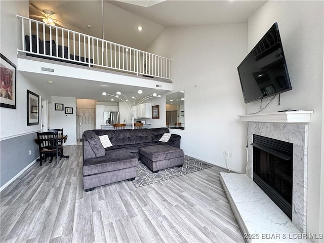 172 Cedar Glen Dr Unit 4B, Camdenton, MO 65020 - living area featuring high vaulted ceiling, light wood-style flooring, a premium fireplace, baseboards, and ceiling fan