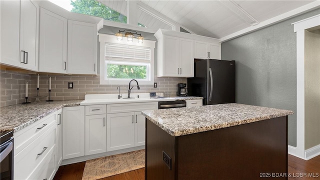 kitchen featuring black appliances, decorative backsplash, dark wood-style floors, lofted ceiling, and white cabinetry