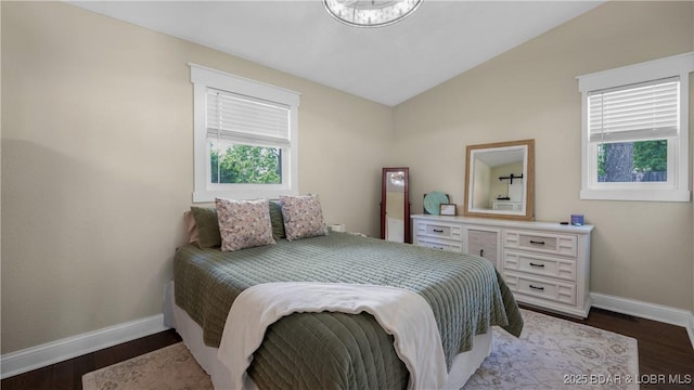 bedroom with baseboards, lofted ceiling, and dark wood finished floors