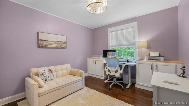 office area with dark wood finished floors, baseboards, and a textured wall