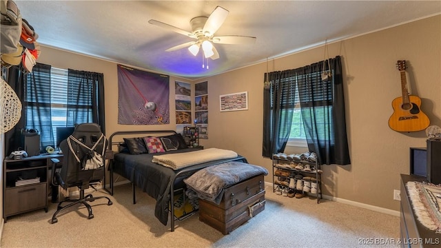 bedroom with light colored carpet, multiple windows, baseboards, a ceiling fan, and ornamental molding