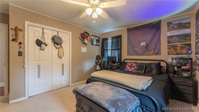 bedroom featuring carpet flooring, a closet, a ceiling fan, baseboards, and crown molding