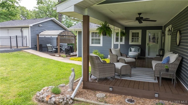 wooden deck with an outdoor living space, a gazebo, a ceiling fan, and a detached garage