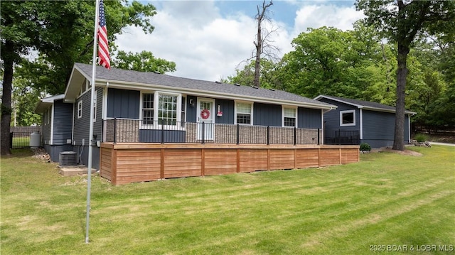 ranch-style home with board and batten siding, a front yard, and central AC unit