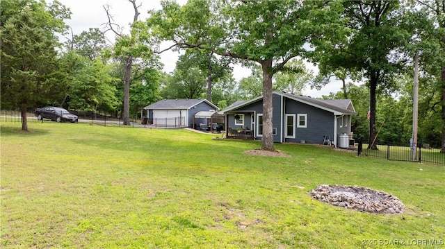 view of yard featuring a detached garage, cooling unit, and an outbuilding