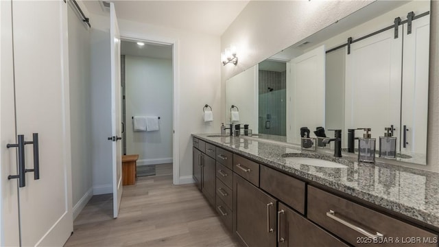 1045 Topsider Ln Unit 314, Osage Beach, MO 65065 - bathroom featuring wood finished floors, baseboards, double vanity, and a shower stall