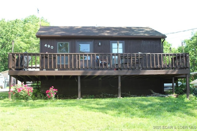 back of house featuring a wooden deck and a lawn