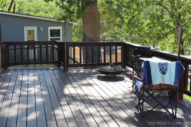 wooden terrace featuring an outdoor fire pit