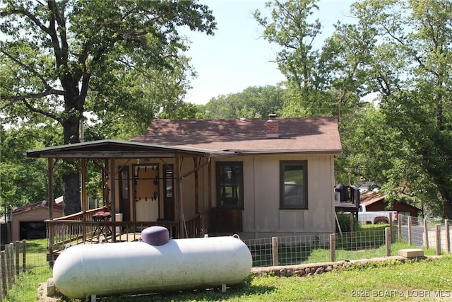 view of front facade with a chimney and roof with shingles