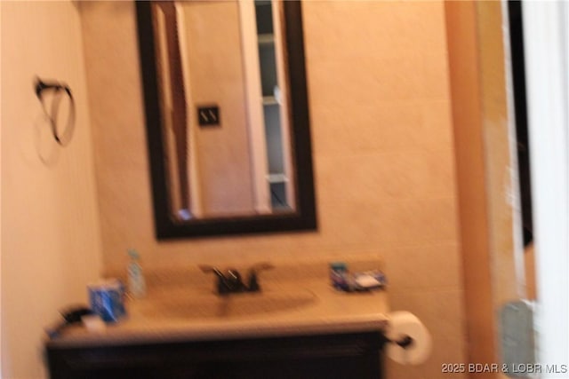 bathroom featuring vanity, tile walls, and tasteful backsplash