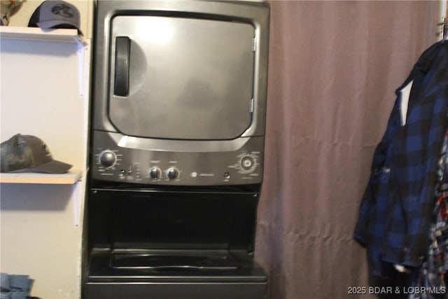 clothes washing area with stacked washer and clothes dryer