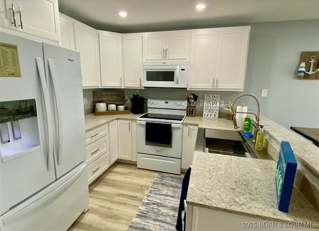 1481 Ledges Dr Unit 1019, Osage Beach, MO 65065 - kitchen with white appliances, a sink, light wood-style floors, white cabinetry, and recessed lighting