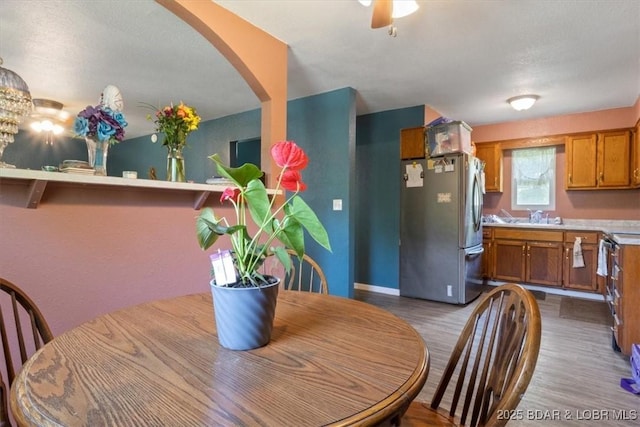 dining space featuring wood finished floors, baseboards, arched walkways, and a chandelier