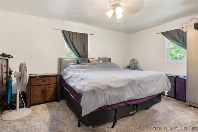 bedroom featuring light carpet and a ceiling fan