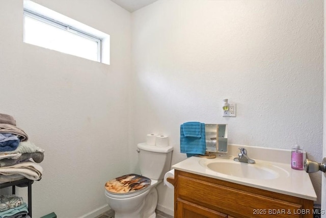 bathroom featuring vanity, toilet, and baseboards