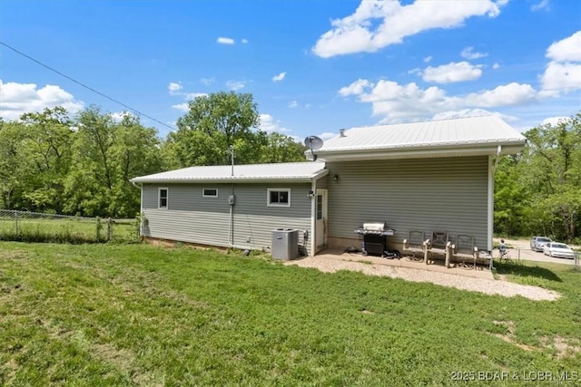 back of house featuring metal roof and central air condition unit