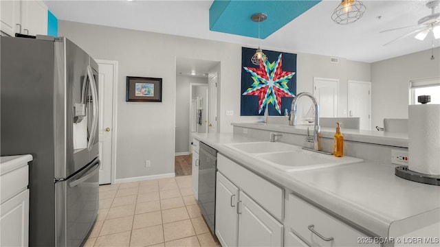 kitchen featuring stainless steel appliances, a sink, a ceiling fan, white cabinets, and light tile patterned floors