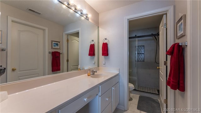 bathroom featuring toilet, a stall shower, and vanity