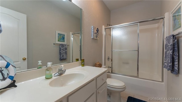 bathroom with vanity, combined bath / shower with glass door, and toilet