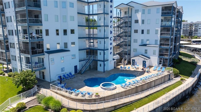 view of apartment building / complex with a pool with connected hot tub