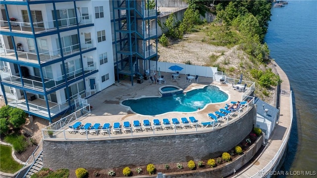aerial view of apartment complex / building, a pool area, and a large body of water