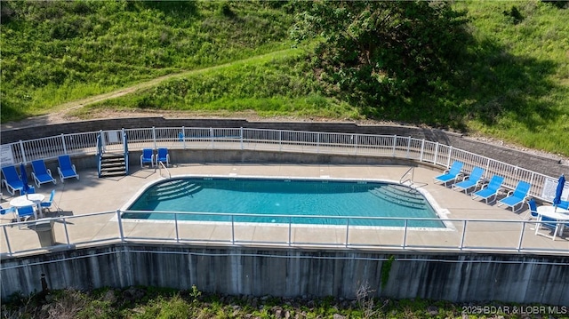 community pool featuring fence and a patio