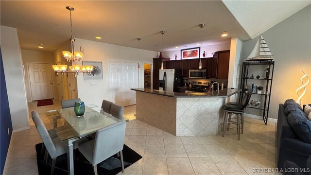 18130 Millstone Cove Rd Unit 447, Gravois Mills, MO 65037 - kitchen with stainless steel appliances, dark countertops, a chandelier, light tile patterned floors, and open floor plan