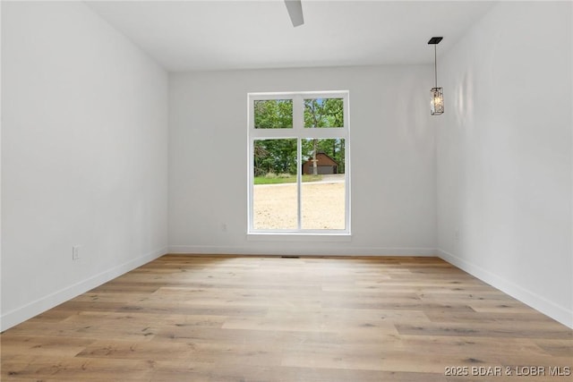 empty room with ceiling fan, baseboards, and light wood-style floors