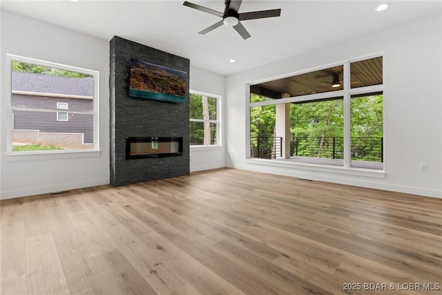 unfurnished living room featuring a large fireplace, baseboards, a ceiling fan, and recessed lighting