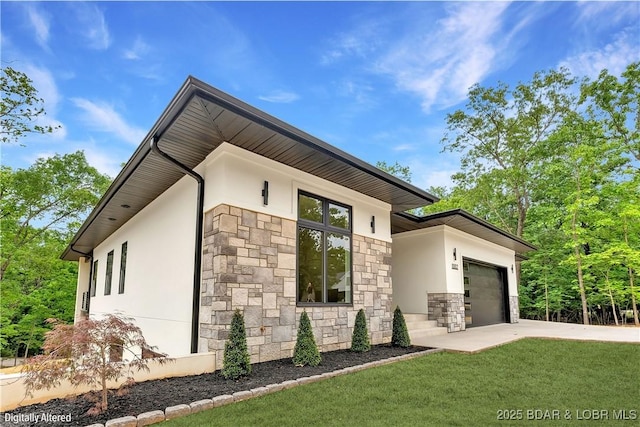 view of side of property with stone siding, stucco siding, an attached garage, a yard, and concrete driveway