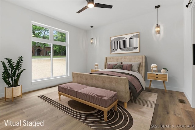 bedroom featuring light wood-style flooring, baseboards, and ceiling fan