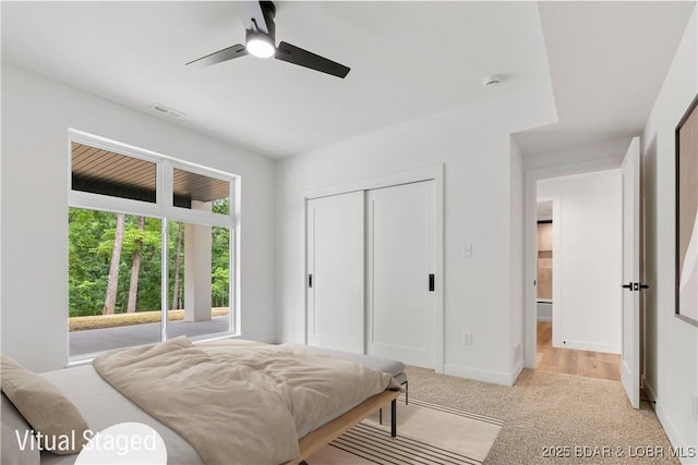 carpeted bedroom featuring a closet, baseboards, and ceiling fan