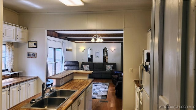 kitchen featuring a sink, wood finished floors, butcher block counters, white cabinetry, and open floor plan