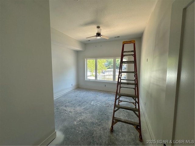 unfurnished room with ceiling fan, baseboards, and concrete floors