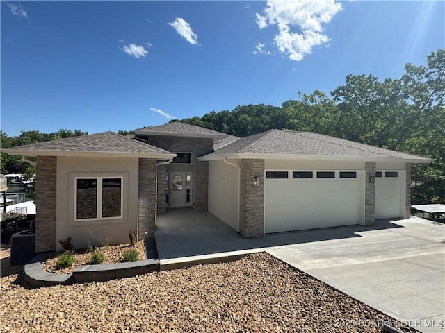 view of front facade featuring an attached garage, driveway, a shingled roof, and stone siding