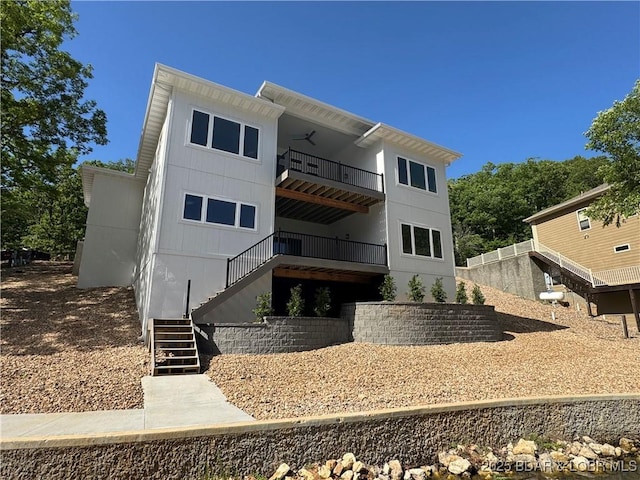 rear view of property featuring stairway and a balcony