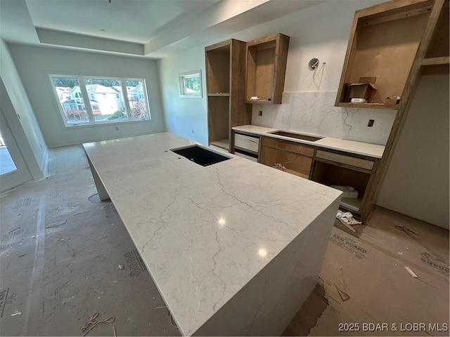 kitchen with a tray ceiling, decorative backsplash, open shelves, and brown cabinets