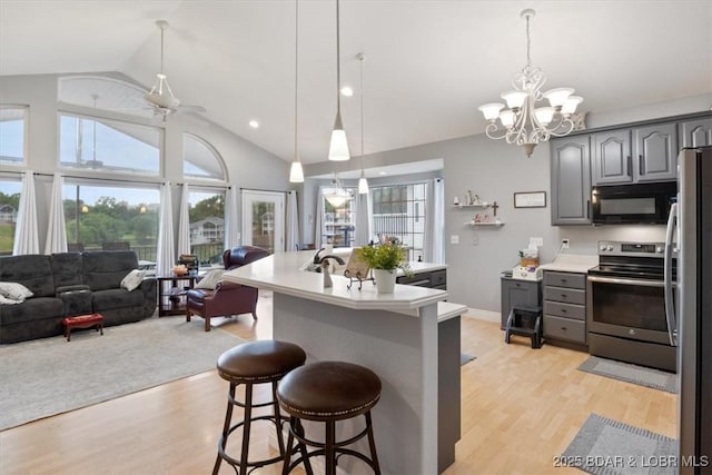 5183 Vicus Castri, Osage Beach, MO 65065 - kitchen with stainless steel appliances, gray cabinets, open floor plan, light countertops, and light wood-type flooring