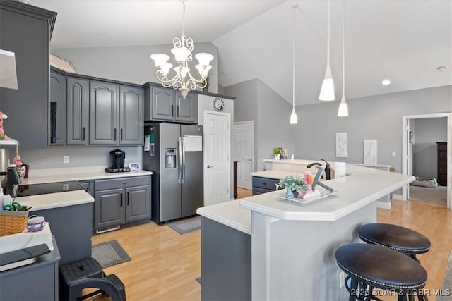 5183 Vicus Castri, Osage Beach, MO 65065 - kitchen featuring stainless steel fridge, lofted ceiling, light wood-style flooring, gray cabinetry, and light countertops