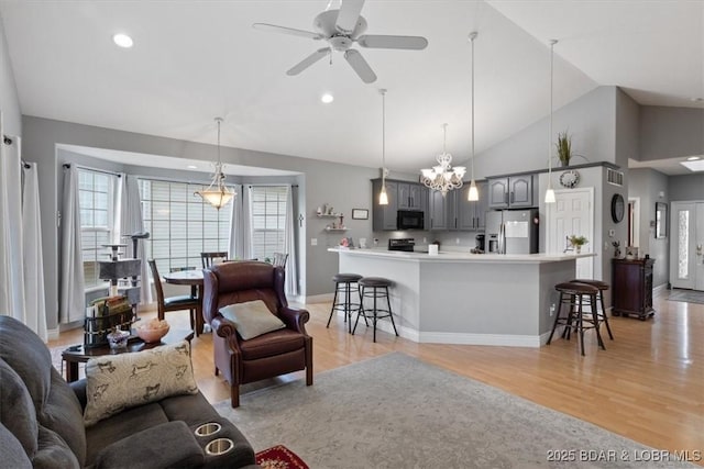 5183 Vicus Castri, Osage Beach, MO 65065 - living room with vaulted ceiling, light wood-type flooring, a ceiling fan, baseboards, and a chandelier