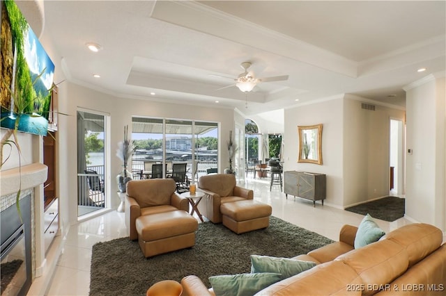 5482 Stoneledge Cir, Osage Beach, MO 65065 - living room featuring a tray ceiling, light tile patterned flooring, recessed lighting, a ceiling fan, and crown molding