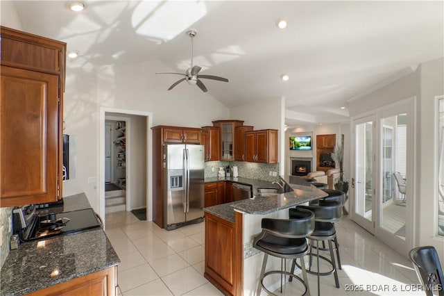 5482 Stoneledge Cir, Osage Beach, MO 65065 - kitchen with appliances with stainless steel finishes, brown cabinets, a peninsula, ceiling fan, and a breakfast bar