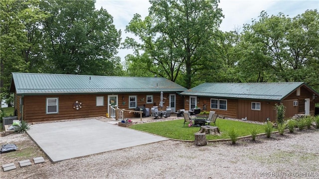 1053 Cedar Ridge Cir, Roach, MO 65787 - view of front of house featuring driveway, cooling unit, a patio area, metal roof, and a front lawn