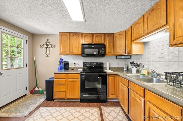66 Old Shawnee Bend Rd, Sunrise Beach, MO 65079 - kitchen featuring black appliances, dark wood-type flooring, a sink, a textured ceiling, and decorative backsplash
