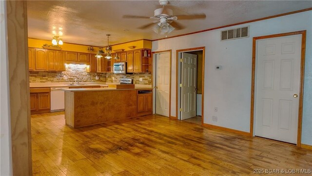26587 Lake Front Ln, Rocky Mount, MO 65072 - kitchen with stainless steel microwave, a sink, dishwasher, light wood-style floors, and ceiling fan